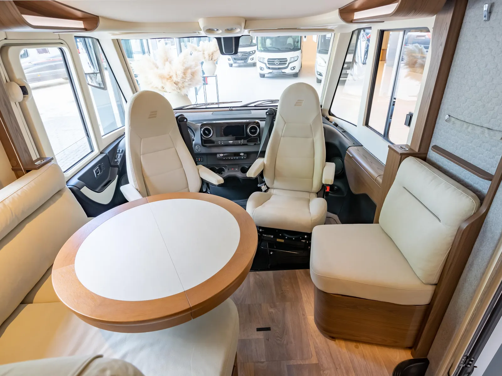 Ruime zithoek met draaistoelen en ronde tafel in een Hymer integraal
