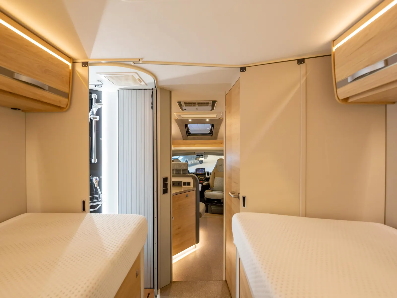 Enkele bedden en badkamer in een Dethleffs-camper
